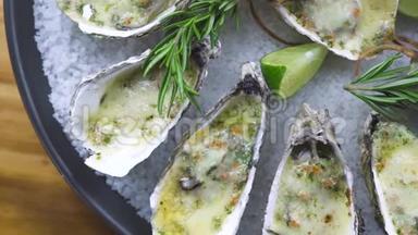 用奶酪、石灰和香草在盘子里烤的牡蛎。 菜单海鲜餐厅。 地中海美食海鲜组合